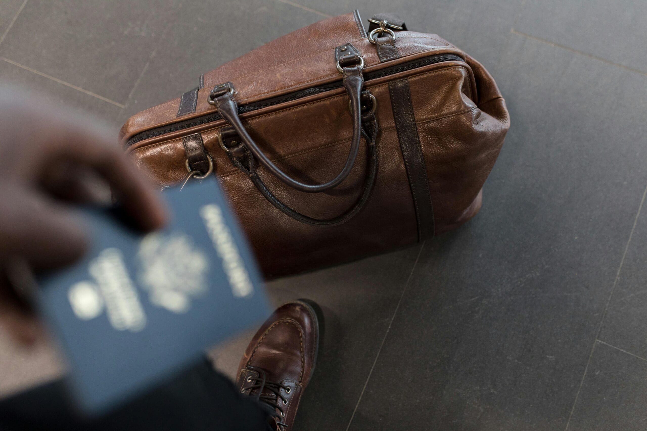 a passport held over a leather bag ready to apply for non-o visa