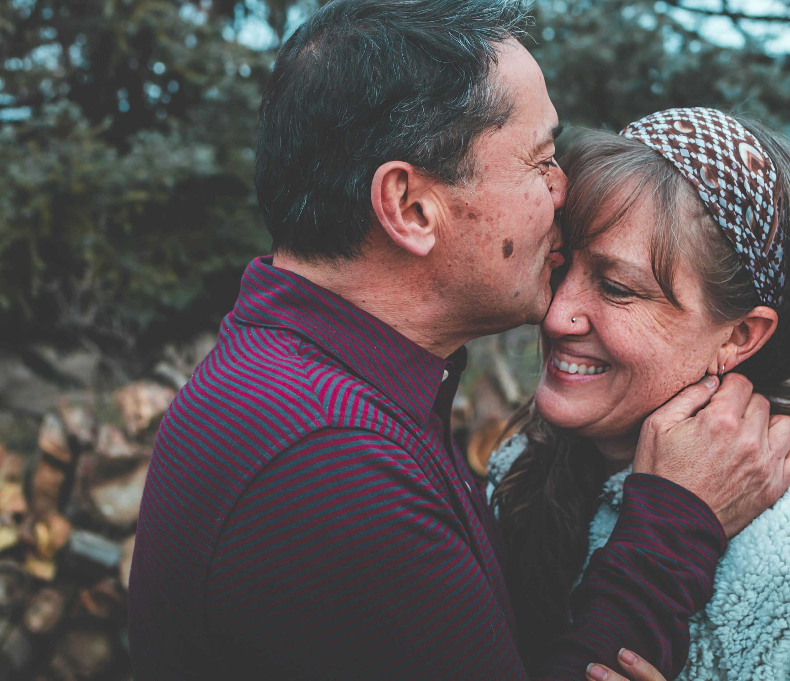 a retired man kissing a woman on the forehead after getting a non-o visa thailand