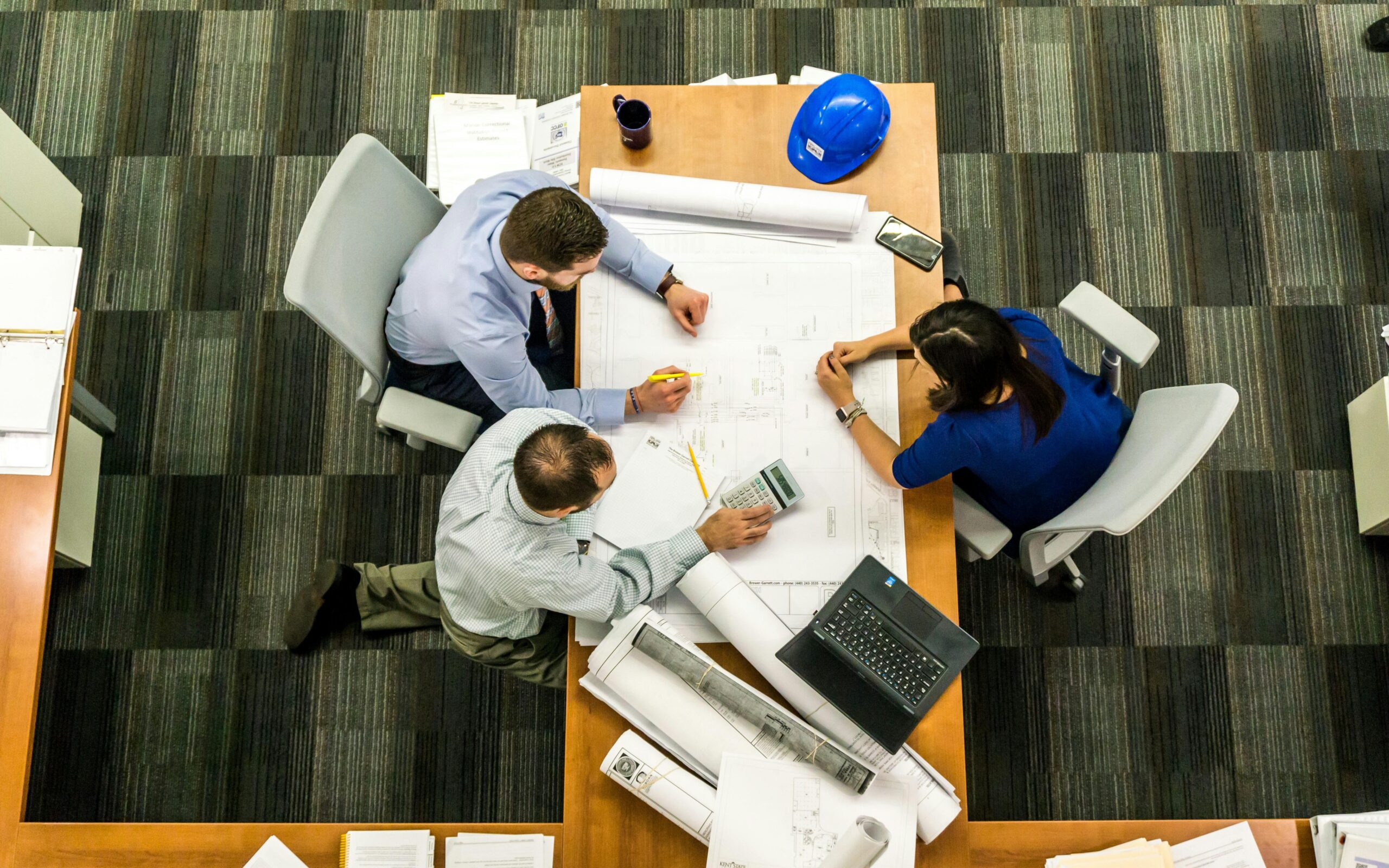 photo of three people in office take from above working at table