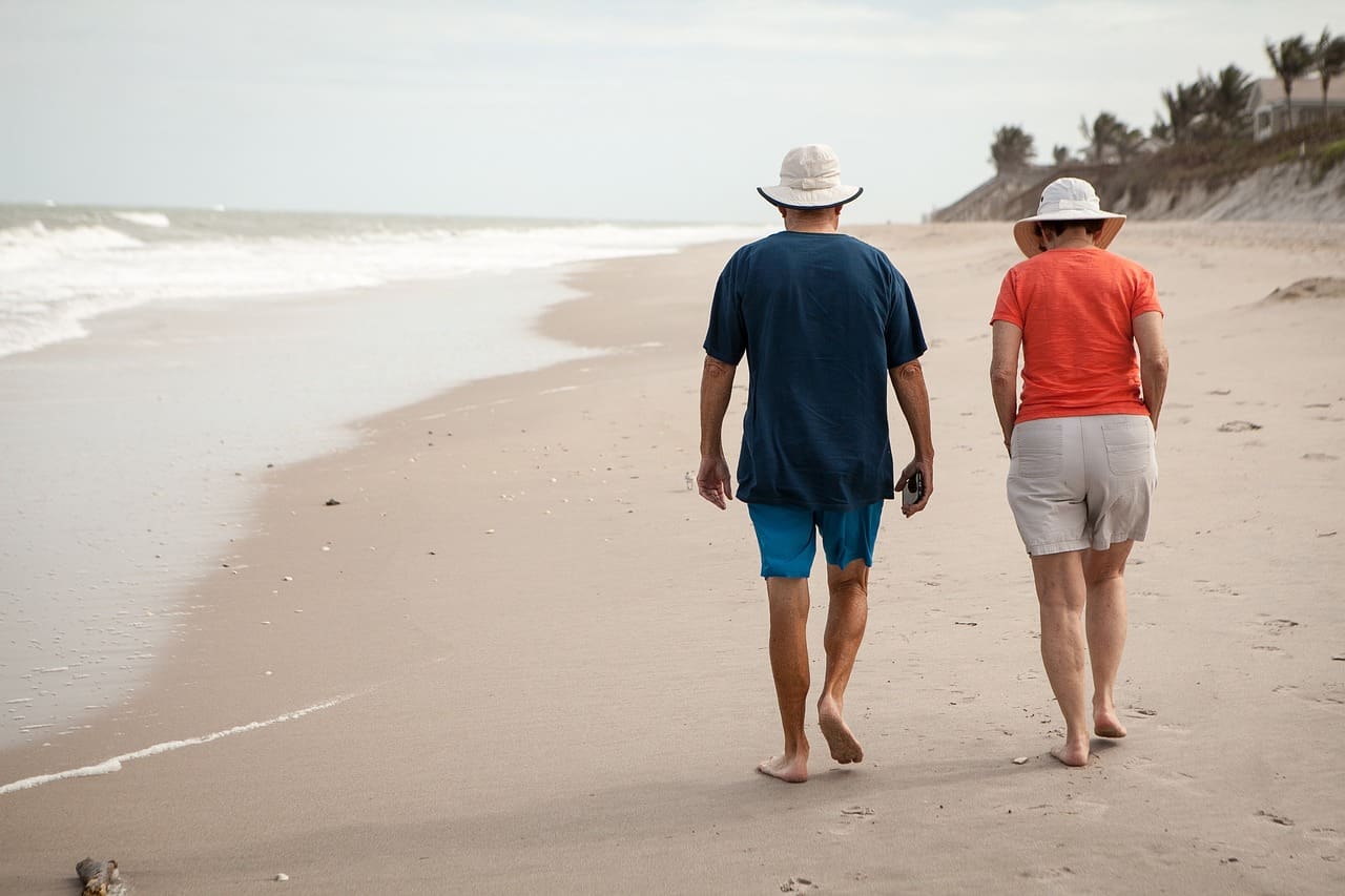 two people walking on a thai beach after retire in thailand