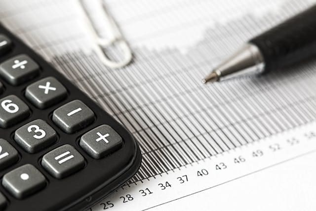 a photo of a calculator and pen over a piece of paper for checking tax before moving abroad