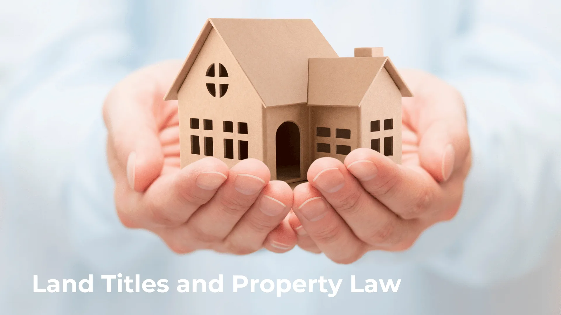 clouds in background with hands holding house in palms with a sign saying land titles and property law